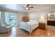 A bright bedroom with a ceiling fan, hardwood floors, and a sliding glass door to the backyard at 14627 N 55Th Pl, Scottsdale, AZ 85254