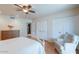 A bedroom with a ceiling fan, multiple closets, hardwood floors, and a comfortable armchair at 14627 N 55Th Pl, Scottsdale, AZ 85254