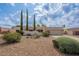 Charming single-story home with xeriscaping, mature trees, and a two-car garage under a partly cloudy sky at 14627 N 55Th Pl, Scottsdale, AZ 85254