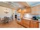 An open kitchen with light wood cabinets, tile floors, and a view of a dining area and living room at 14627 N 55Th Pl, Scottsdale, AZ 85254