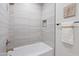 Modern bathroom features a sleek bathtub with tiled walls, a recessed shelf, and a stylish towel rack with white towel at 1642 E Monte Vista Rd # 5, Phoenix, AZ 85006