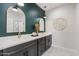 Contemporary bathroom featuring dual sinks, elegant mirrors, and stylish lighting fixtures against a dark accent wall at 1642 E Monte Vista Rd # 5, Phoenix, AZ 85006