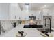 Stylish kitchen featuring marble backsplash, white cabinets, and stainless steel appliances at 1642 E Monte Vista Rd # 5, Phoenix, AZ 85006