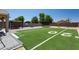 Large backyard featuring artificial turf football field, basketball hoop, trampoline, and shaded outdoor living area at 18575 W Vogel Ave, Goodyear, AZ 85338