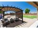 Expansive backyard oasis with a covered patio, built-in firepit, and low-maintenance landscaping at 18575 W Vogel Ave, Goodyear, AZ 85338