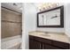 Well-lit bathroom featuring a shower-tub combo with decorative tile accent and vanity with granite countertop at 19601 N 7Th N St # 1072, Phoenix, AZ 85024