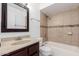 Well-lit bathroom featuring a shower-tub combo with decorative tile accent and vanity with granite countertop at 19601 N 7Th N St # 1072, Phoenix, AZ 85024