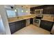 Kitchen with stainless steel appliances, a dual basin sink, dark cabinets and neutral color countertops at 19601 N 7Th N St # 1072, Phoenix, AZ 85024