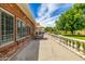 Spacious backyard featuring a brick home exterior, covered patio with dining set, and a meticulously manicured lawn at 198 N Pecan Ct, Gilbert, AZ 85234
