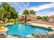 Lush backyard showcasing a sparkling pool, well-maintained landscaping, and a charming tan home at 198 N Pecan Ct, Gilbert, AZ 85234
