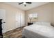 Bright bedroom featuring wood-look floors, a ceiling fan, and natural light at 198 N Pecan Ct, Gilbert, AZ 85234