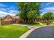 Beautiful brick home featuring a gated driveway, mature trees, and meticulously maintained landscaping at 198 N Pecan Ct, Gilbert, AZ 85234