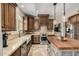 Gourmet kitchen featuring dark wood cabinetry, stainless steel appliances, and center island with butcher block top at 198 N Pecan Ct, Gilbert, AZ 85234