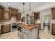 Beautiful kitchen featuring custom cabinets, stainless steel appliances, kitchen island, and unique pendant lighting at 198 N Pecan Ct, Gilbert, AZ 85234
