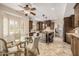 Open concept kitchen with wood cabinets, stainless appliances, center island, and a breakfast table surrounded by windows at 198 N Pecan Ct, Gilbert, AZ 85234