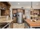 Gourmet kitchen with stainless steel appliances, wine rack, custom cabinets, and a center island with a butcher block top at 198 N Pecan Ct, Gilbert, AZ 85234