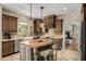 Elegant kitchen with custom cabinetry, a farmhouse sink, granite counters, and an island with seating at 198 N Pecan Ct, Gilbert, AZ 85234