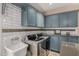 Contemporary laundry room featuring custom cabinets, stainless appliances, tile backsplash, utility sink, and granite countertops at 198 N Pecan Ct, Gilbert, AZ 85234