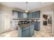 Well-equipped laundry room with custom blue cabinets, subway tile, granite counters, stainless washer/dryer and center island at 198 N Pecan Ct, Gilbert, AZ 85234