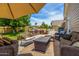 Charming backyard featuring an outdoor kitchen, comfortable seating beneath an umbrella, and lush greenery at 198 N Pecan Ct, Gilbert, AZ 85234