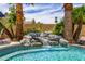 Serene pool with custom rock waterfall feature, surrounded by lush landscaping, creating a backyard oasis at 198 N Pecan Ct, Gilbert, AZ 85234