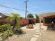 Landscaped backyard with mature palms and plantings, stone fire pit, outdoor kitchen, and covered patio at 2027 N 81St St, Scottsdale, AZ 85257