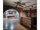 Basement featuring a wet bar, hardwood floors, brick accents, and an open layout for entertaining at 2027 N 81St St, Scottsdale, AZ 85257