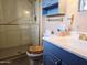 Bathroom with glass shower, blue vanity and toilet at 2027 N 81St St, Scottsdale, AZ 85257