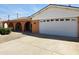 View of the garage side of this single-Gathering home, featuring a two-car garage, xeriscaping, and arched doorway at 2027 N 81St St, Scottsdale, AZ 85257