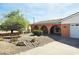 Charming single-Gathering home featuring stucco walls, arched doorway and windows, xeriscaping, and a driveway leading to a garage at 2027 N 81St St, Scottsdale, AZ 85257