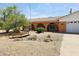 Charming single-Gathering home featuring stucco walls, arched doorway and windows, xeriscaping, and a driveway leading to a garage at 2027 N 81St St, Scottsdale, AZ 85257
