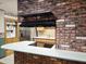 Charming kitchen boasting modern appliances, a cooktop, and sleek countertops set against a brick accent wall at 2027 N 81St St, Scottsdale, AZ 85257