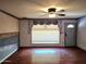 View of a living room featuring hardwood floors, ceiling fan, a large window, and front door at 2027 N 81St St, Scottsdale, AZ 85257