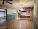 Open-concept living space, featuring hardwood floors, brick wall kitchen, and a stainless steel refrigerator at 2027 N 81St St, Scottsdale, AZ 85257