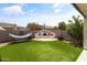 Inviting backyard features synthetic grass, a hammock, and an outdoor fireplace for relaxation and entertainment at 2105 E San Carlos Pl, Chandler, AZ 85249