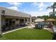Backyard featuring a pool, patio with an outdoor dining area, and a well-maintained synthetic grass lawn at 2105 E San Carlos Pl, Chandler, AZ 85249