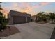 Charming home with a three-car garage, beautiful desert landscaping, and a spacious driveway at dusk at 2105 E San Carlos Pl, Chandler, AZ 85249
