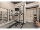 This home gym features a treadmill and various workout equipment, with mirrors for monitoring form and a TV for entertainment at 2105 E San Carlos Pl, Chandler, AZ 85249