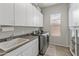 Well-organized laundry room featuring a sink, countertop, ample cabinetry, and modern washer and dryer at 2105 E San Carlos Pl, Chandler, AZ 85249
