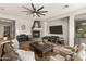 Inviting living room features a cozy fireplace, a large ceiling fan, and elegant furnishings at 2105 E San Carlos Pl, Chandler, AZ 85249