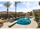 Inviting backyard oasis with a sparkling pool, rock features, diving board, and lounge area for ultimate relaxation and enjoyment at 2105 E San Carlos Pl, Chandler, AZ 85249