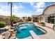 Gorgeous backyard pool with rock waterfall feature, diving board, and ample space for outdoor entertaining and relaxation at 2105 E San Carlos Pl, Chandler, AZ 85249