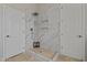 The beautifully tiled shower stall has a rainfall showerhead and built-in shelving, offering both style and convenience at 2105 E San Carlos Pl, Chandler, AZ 85249