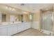 Bright bathroom featuring a double vanity, bathtub, and glass-enclosed shower at 21610 N Bradford Dr, Maricopa, AZ 85138