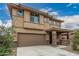 Welcoming front elevation showcasing a two-story home with a covered entryway and two-car garage at 21610 N Bradford Dr, Maricopa, AZ 85138