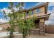 Two story home with neutral color palette and landscaped front yard featuring desert landscaping at 21610 N Bradford Dr, Maricopa, AZ 85138