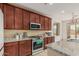 Kitchen with dark wood cabinets and granite countertops and stainless steel appliances at 21610 N Bradford Dr, Maricopa, AZ 85138