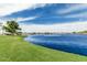 Picturesque lakeside view with lush green landscaping, showcasing the tranquil beauty and community amenities at 21610 N Bradford Dr, Maricopa, AZ 85138