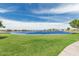 Serene lakefront view showcasing the waterfront homes and lush green spaces in the surrounding community at 21610 N Bradford Dr, Maricopa, AZ 85138