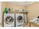 Functional laundry room with washer, dryer, and storage shelves at 21610 N Bradford Dr, Maricopa, AZ 85138